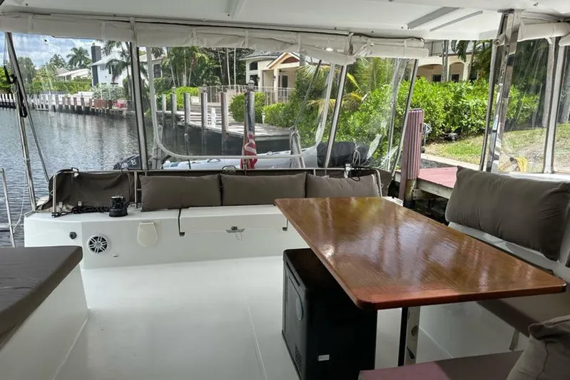 Waterlilly Yacht Photos Pics 2017 Fountaine Pajot Lucia 40 catamaran interior with seating and table, docked by a canal.