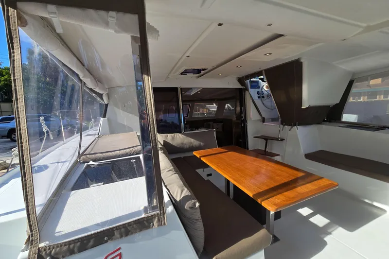 Waterlilly Yacht Photos Pics 2017 Fountaine Pajot Lucia 40 catamaran interior with seating and wooden table.