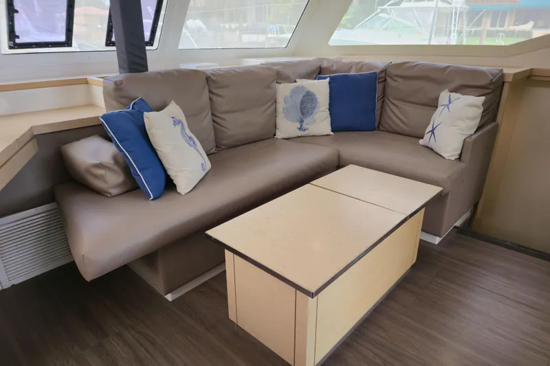 Waterlilly Yacht Photos Pics Luxurious interior of 2017 Fountaine Pajot Lucia 40 catamaran with cozy seating and nautical-themed cushions.