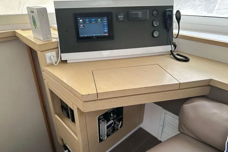 Waterlilly Yacht Photos Pics Navigation station on 2017 Fountaine Pajot Lucia 40 catamaran with control panel and seating.