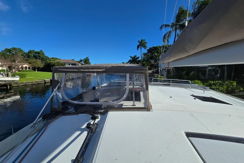 Waterlilly Yacht Photos Pics 2017 Fountaine Pajot Lucia 40 catamaran docked by lush greenery and clear blue sky.