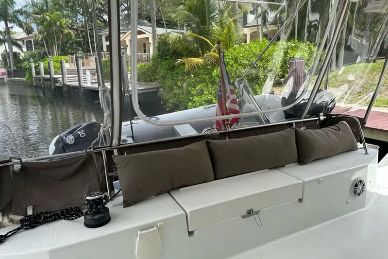 Waterlilly Yacht Photos Pics 2017 Fountaine Pajot Lucia 40 catamaran with seating area, docked by lush greenery.