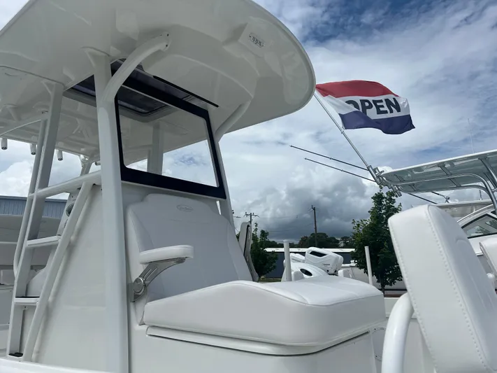  Yacht Photos Pics 2026 Pair Customs 27 Center Console boat with open flag, under cloudy sky.