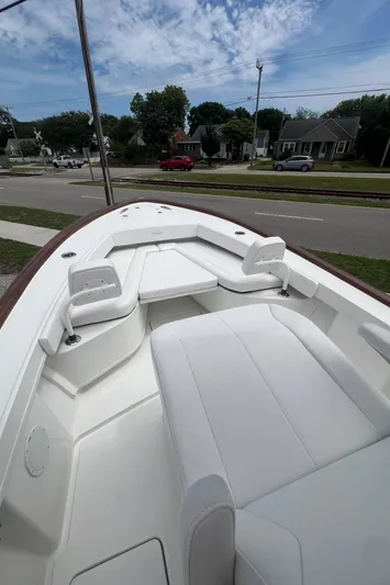  Yacht Photos Pics 2026 Pair Customs 27 Center Console boat with white seating, parked near a suburban street.