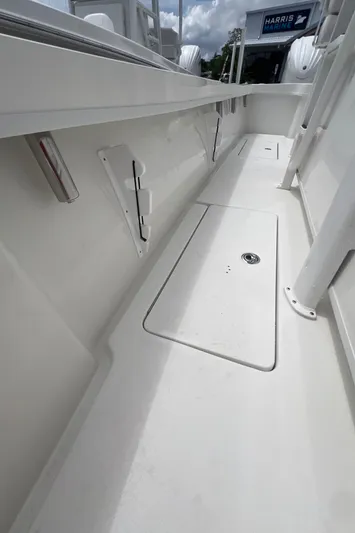  Yacht Photos Pics 2026 Pair Customs 27 Center Console boat interior, featuring sleek white deck and storage compartments.