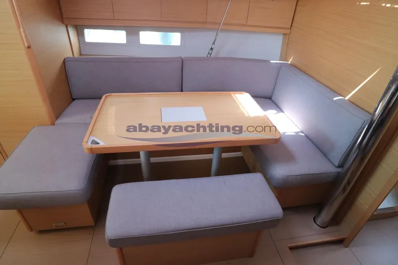 Yacht Photos Pics 2018 Dufour 412 Grand Large yacht interior with cozy seating and wooden table.