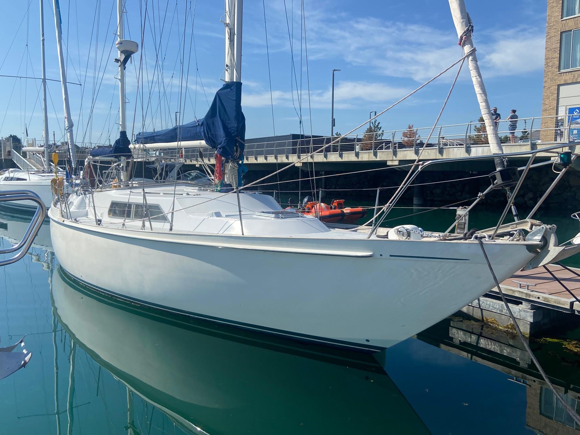 1978 Nicholson 48 Ketch sailboat docked in a marina under clear blue skies.