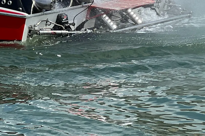  Yacht Photos Pics 2004 Spectre 36 Cat boat on water, showcasing rear section and wake.