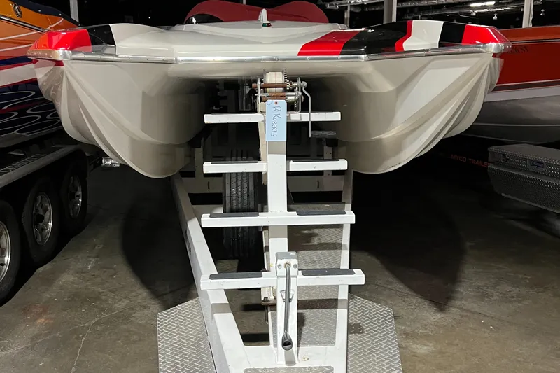  Yacht Photos Pics 2004 Spectre 36 Cat boat on trailer, viewed from the front in a garage setting.