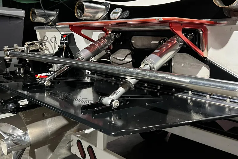  Yacht Photos Pics Close-up of 2004 Spectre 36 Cat boat's rear with hydraulic components and Mercury branding.