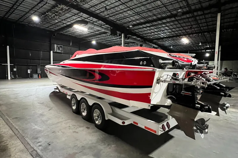  Yacht Photos Pics 2004 Spectre 36 Cat powerboat with red and black design on a triple-axle trailer in a warehouse.