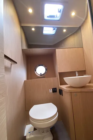  Yacht Photos Pics Modern bathroom in 2026 Beneteau 41 Swift Trawler FLY with skylight and porthole.