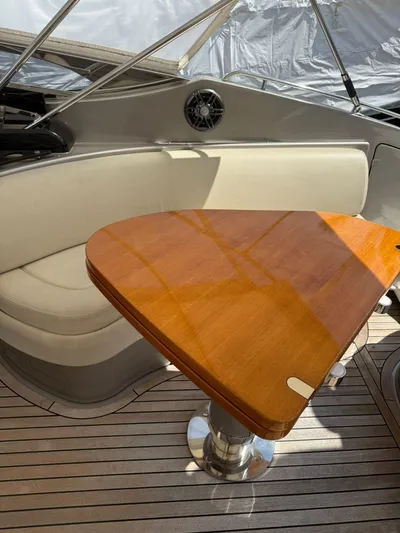  Yacht Photos Pics Luxurious 2012 Riva Rivale yacht interior with elegant wood table and cushioned seating.