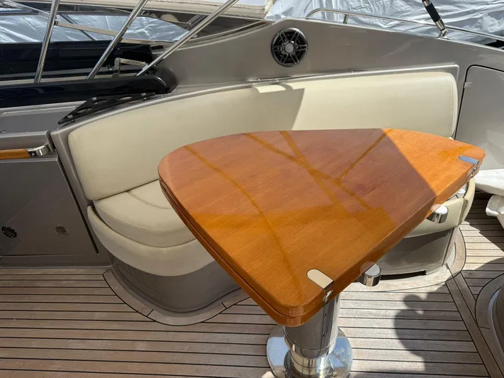  Yacht Photos Pics 2012 Riva Rivale yacht interior with wooden table and cushioned seating.