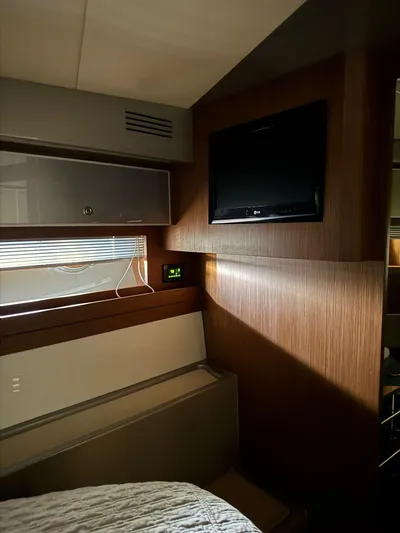  Yacht Photos Pics Interior of a 2012 Riva Rivale yacht cabin with TV and modern wood paneling.