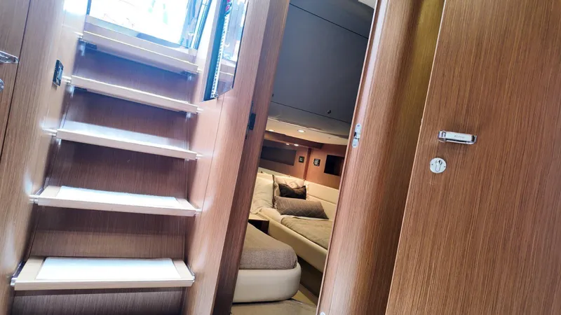  Yacht Photos Pics Interior of 2012 Riva Rivale yacht, featuring wooden stairs and a cozy cabin.