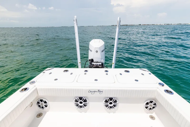  Yacht Photos Pics 2023 Canyon Bay 28h boat on open water, showcasing deck and motor.