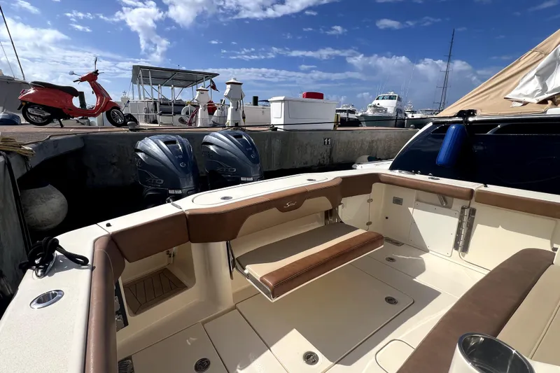 Bachita Yacht Photos Pics 2023 Scout 355 LXF boat interior with twin engines at a marina.