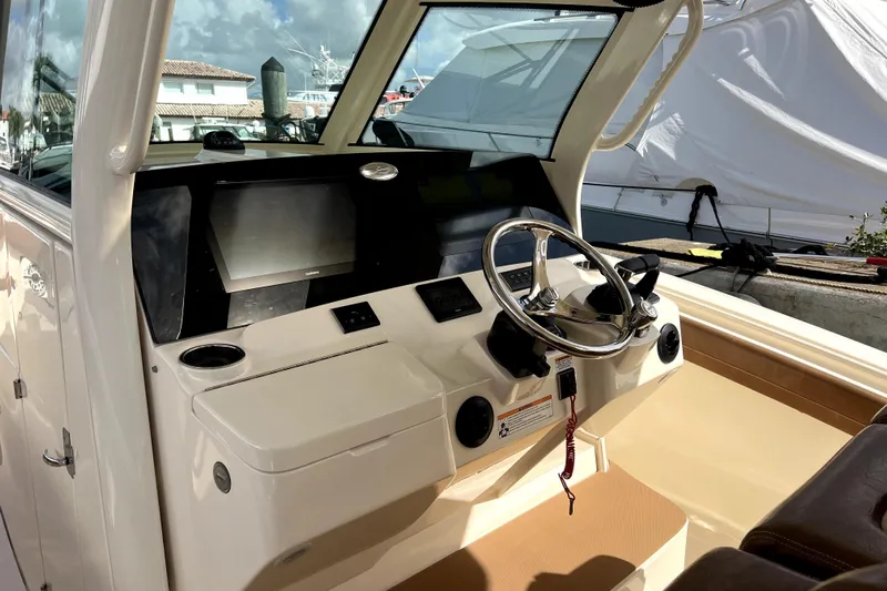 Bachita Yacht Photos Pics 2023 Scout 355 LXF boat helm with steering wheel and navigation screens.