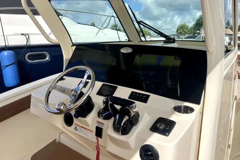 Bachita Yacht Photos Pics 2023 Scout 355 LXF boat dashboard with steering wheel and navigation controls.