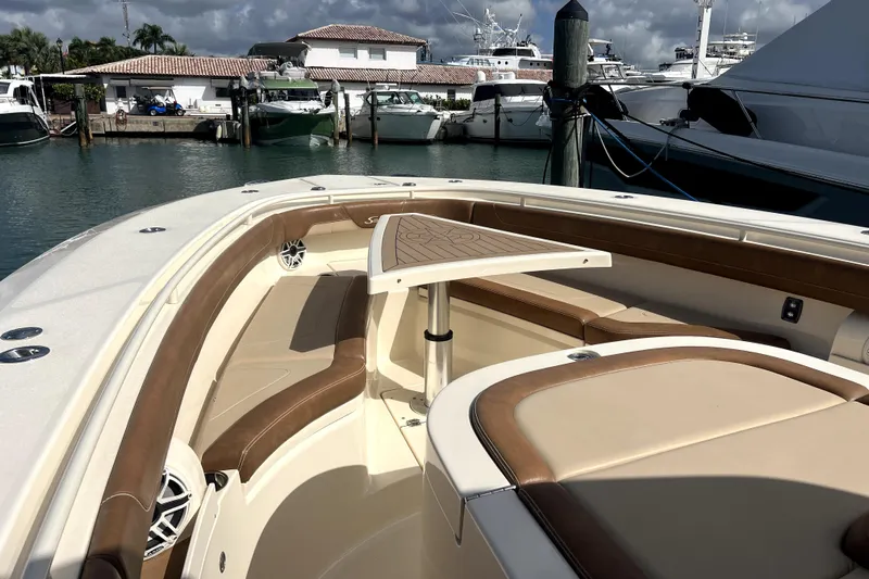 Bachita Yacht Photos Pics 2023 Scout 355 LXF boat interior with seating and table, docked at marina.