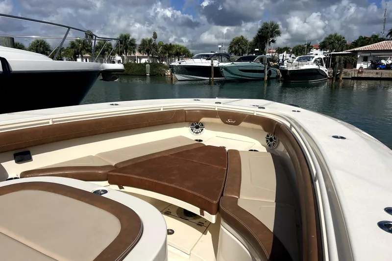 Bachita Yacht Photos Pics 2023 Scout 355 LXF boat interior with luxurious seating, docked in a marina.