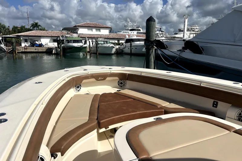 Bachita Yacht Photos Pics 2023 Scout 355 LXF boat interior with luxurious seating at a marina.