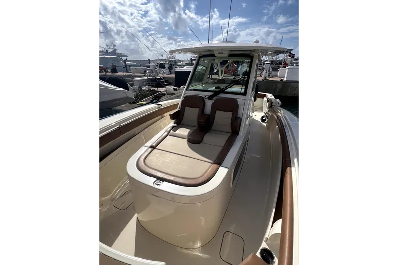 Bachita Yacht Photos Pics 2023 Scout 355 LXF boat with luxurious seating and sleek design at a marina.