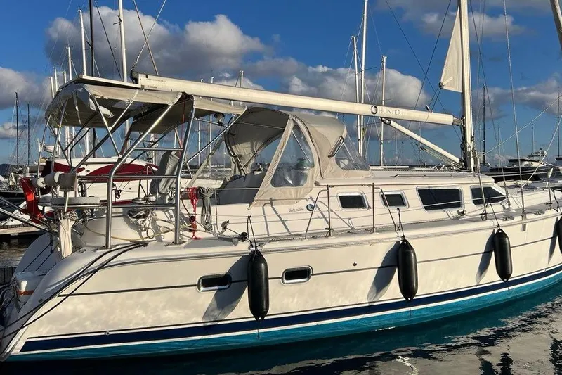 1754 Yacht Photos Pics 2004 Hunter 426 Owners Version sailboat docked at marina under blue sky.