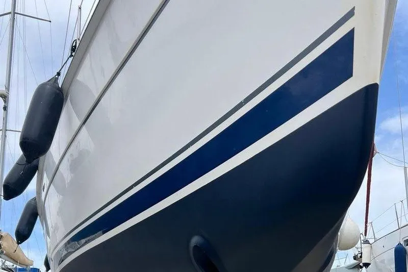 1754 Yacht Photos Pics 2004 Hunter 426 Owners Version sailboat with blue stripe, docked and ready for sailing.