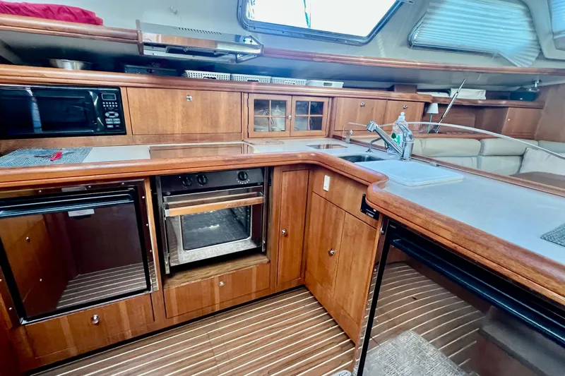 1754 Yacht Photos Pics Interior of 2004 Hunter 426 Owners Version yacht kitchen with wood cabinetry and appliances.