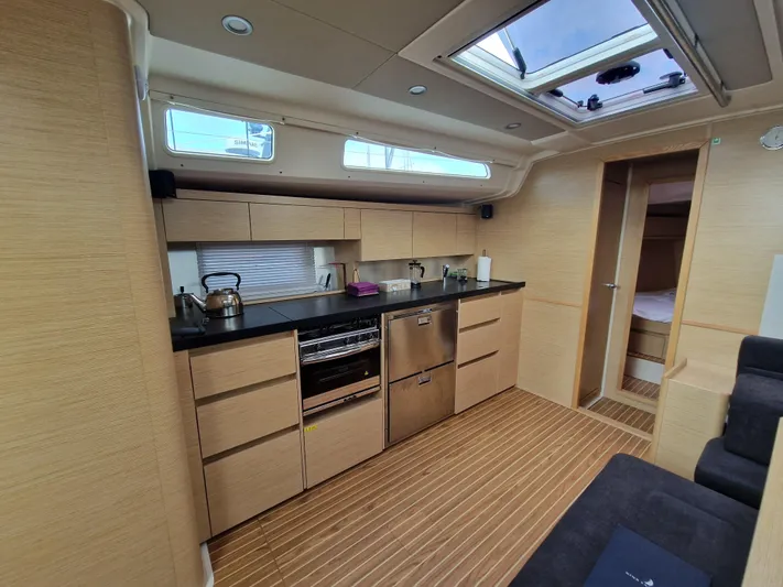  Yacht Photos Pics Modern kitchen interior of 2020 Hanse 508 yacht with wooden cabinetry and skylight.