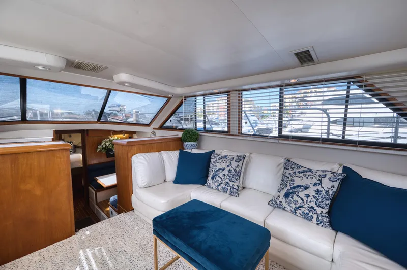 Radiant Yacht Photos Pics Luxurious interior of 1991 Californian 48 Sundeck Motor Yacht with white sofa and blue accents.