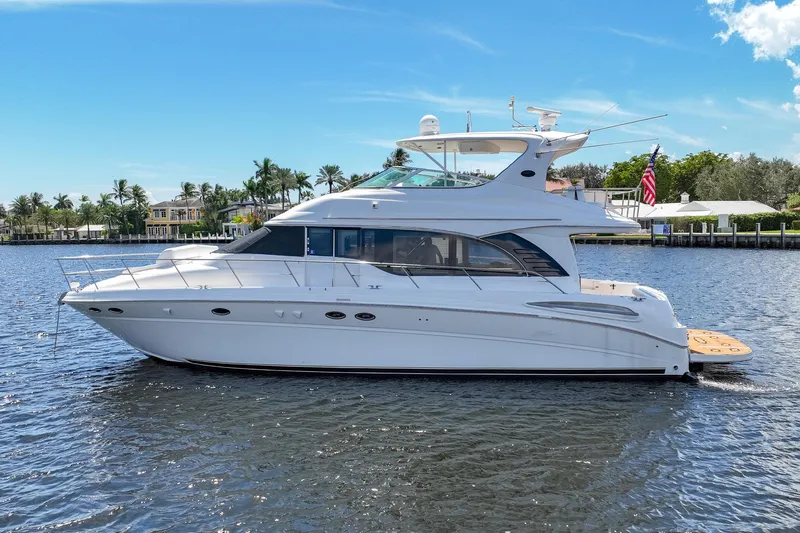 L'attitude Adjustment Yacht Photos Pics 2001 Sea Ray 540 Cockpit Motor Yacht on calm water, clear sky background.