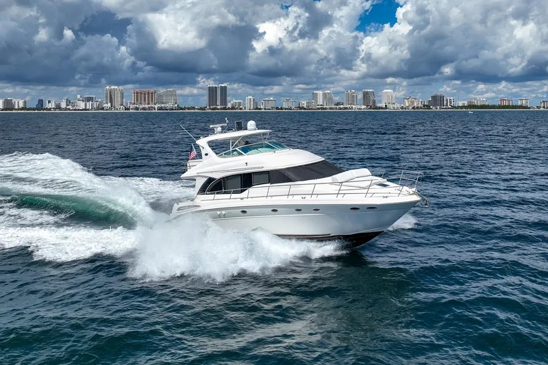 L'attitude Adjustment Yacht Photos Pics 2001 Sea Ray 540 Cockpit Motor Yacht cruising on ocean with city skyline backdrop.