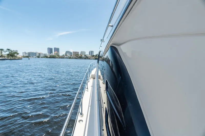 L'attitude Adjustment Yacht Photos Pics Side view of 2001 Sea Ray 540 Cockpit Motor Yacht on water, city skyline in background.