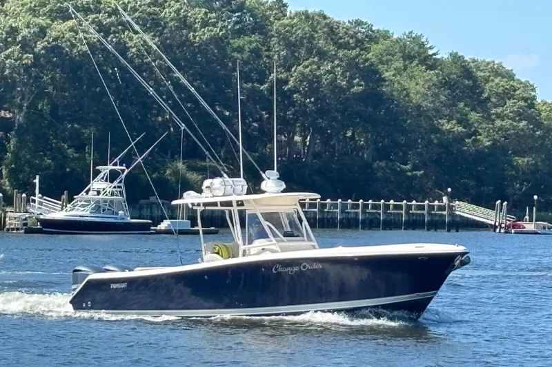  Yacht Photos Pics 2014 Pursuit C 310 Center Console boat cruising on a scenic waterway.