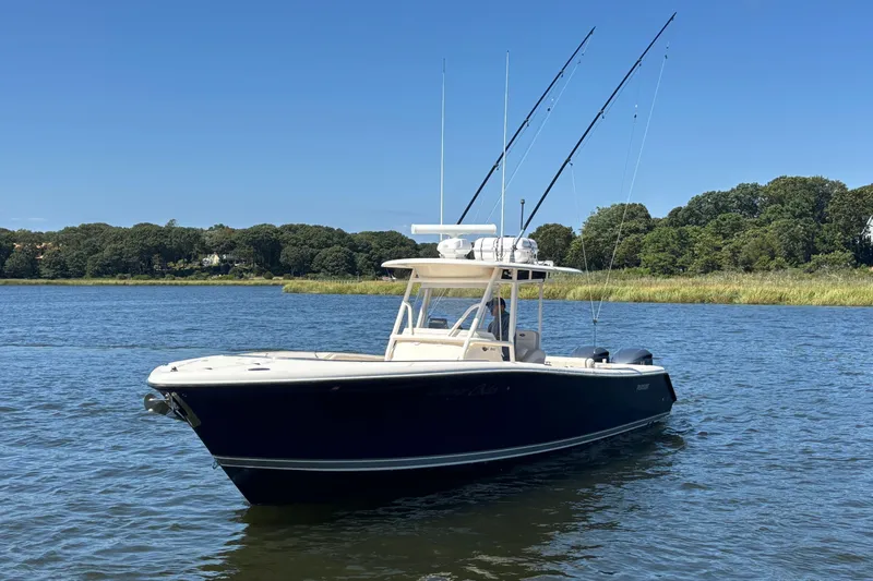  Yacht Photos Pics 2014 Pursuit C 310 Center Console boat on calm water, clear sky background.