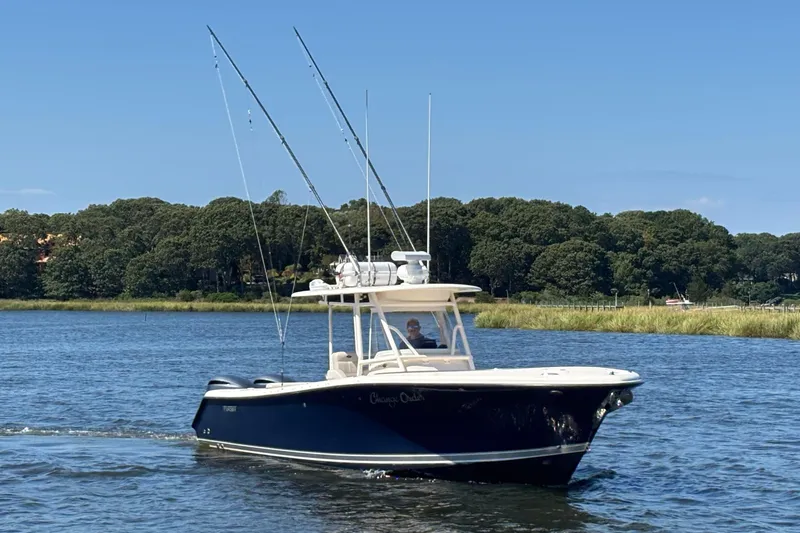  Yacht Photos Pics 2014 Pursuit C 310 Center Console boat cruising on a scenic lake.