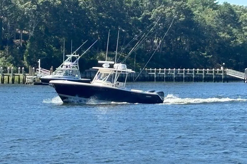  Yacht Photos Pics 2014 Pursuit C 310 Center Console boat cruising on a scenic waterway.