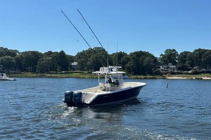  Yacht Photos Pics 2014 Pursuit C 310 Center Console boat on a calm lake with fishing rods.
