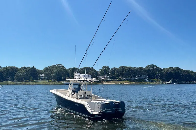  Yacht Photos Pics 2014 Pursuit C 310 Center Console boat on water with fishing rods.