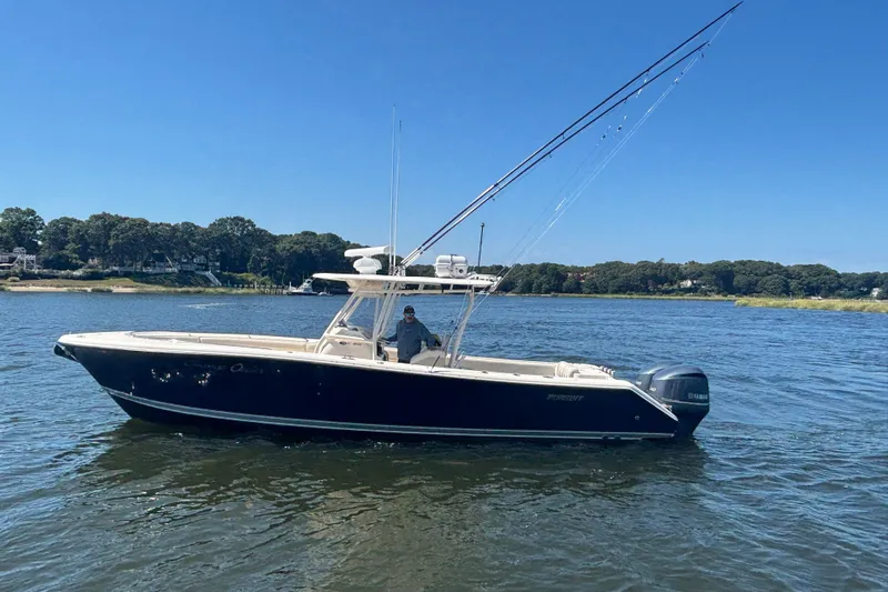  Yacht Photos Pics 2014 Pursuit C 310 Center Console boat on calm water under clear blue sky.