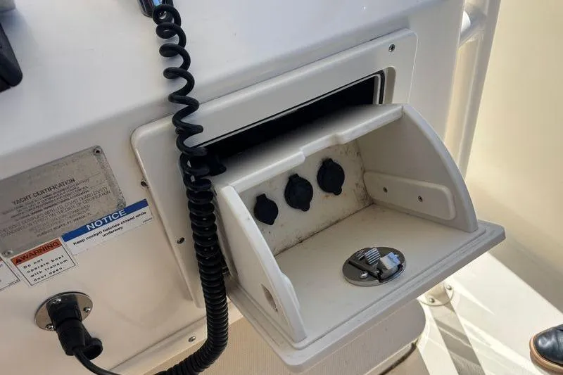  Yacht Photos Pics 2014 Pursuit C 310 Center Console control panel with open compartment and switches.