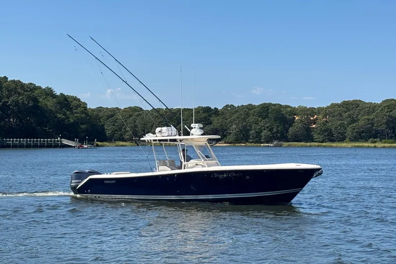  Yacht Photos Pics 2014 Pursuit C 310 Center Console boat cruising on a scenic lake.