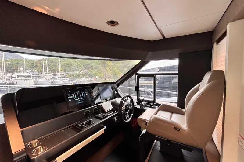T&b Yacht Photos Pics Pilothouse of 2025 Azimut Magellano 66 yacht with modern controls and leather captain's chair.