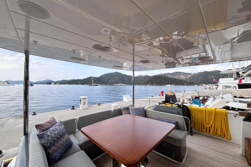T&b Yacht Photos Pics Outdoor seating area on 2025 Azimut Magellano 66 yacht, docked with scenic water view.