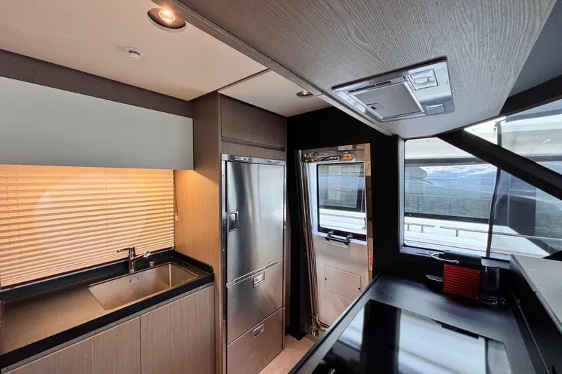 T&b Yacht Photos Pics Modern kitchen interior of 2025 Azimut Magellano 66 yacht, featuring sleek design and appliances.