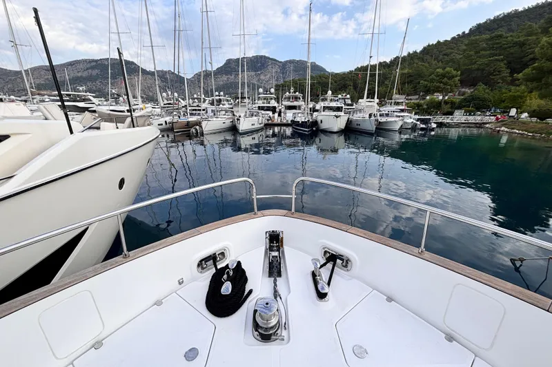 T&b Yacht Photos Pics Bow view of 2025 Azimut Magellano 66 yacht docked in a scenic marina.