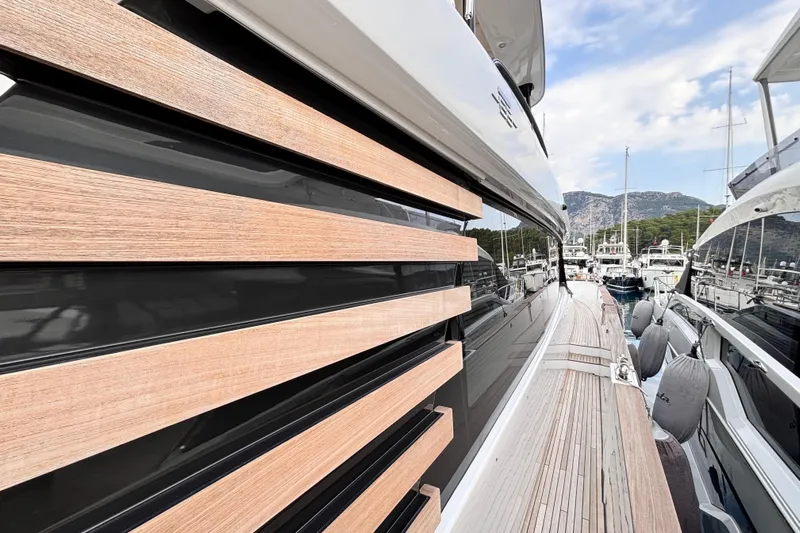 T&b Yacht Photos Pics 2025 Azimut Magellano 66 yacht with sleek wooden paneling in a marina setting.